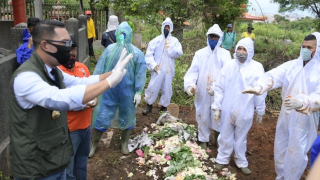 Gubernur Jawa Barat Ridwan Kamil (kiri) meninjau proses pemakaman pasien COVID-19 di TPU Cikadut, Kota Bandung, Rabu (8/4). Foto: Humas Jabar/Pipin
