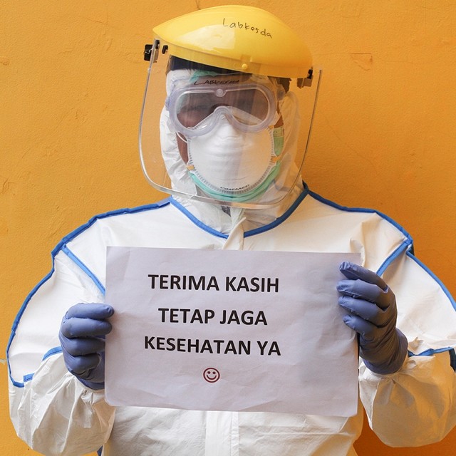 Petugas medis menunjukkan imbauan untuk masyarakat terkait virus corona seusai melaksanakan SWAB Test di Cimanggis, Depok, Jawa Barat, Minggu (8/4). Foto: ANTARA FOTO/Asprilla Dwi Adha