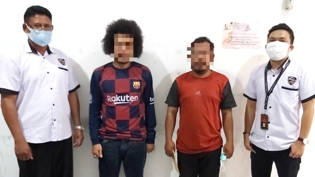 Dua pelaku (tengah) penyebar hoaks pasien COVID-19 di Poso saat diamankan Polda Sulteng. Foto: Dok. Humas Polda Sulteng