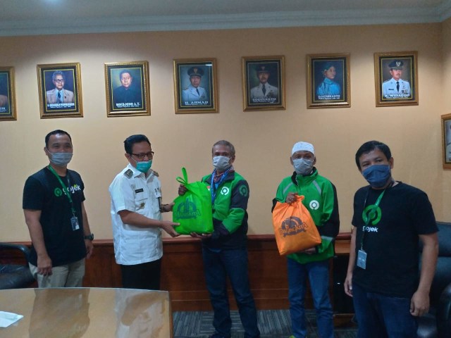 Wakil Walikota Yogyakarta, Heroe Poerwadi, memberikan paket sembako pada driver Gojek berusia di atas 60 tahun, FX Edy Baliawan dan Ngadimin Sunyoto, Rabu (8/4/2020). Foto: Istimewa.