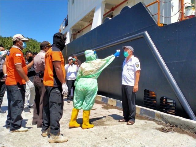 Salah satu petugas Tim Satgas Covid-19 Halbar, saat memeriksa petugas kapal KM. Nusantara 3 menggunakan alat termometer. Foto: istimewa