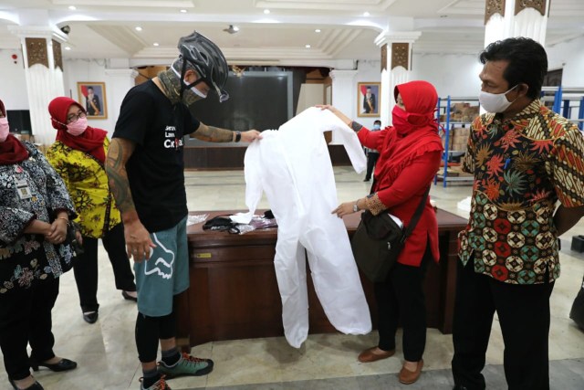 Gubernur Jawa Tengah, Ganjar Pranowo, melihat alat pelindung diri (APD) karya pelajar SMK di Jawa Tengah, Rabu (8/4/2020). Foto: ari