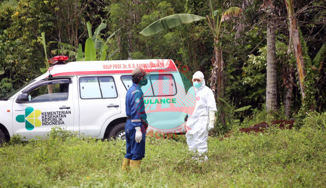 Mobil ambulance yang membawa jenazah Pasien COVID-19 berada di lokasi pekuburan. Jenazah sendiri belum dikuburkan karena Dinas Kesehatan Kabupaten Minahasa Utara tak kunjung datang ke lokasi pekuburan (foto: febry kodongan/manadobacirita) 