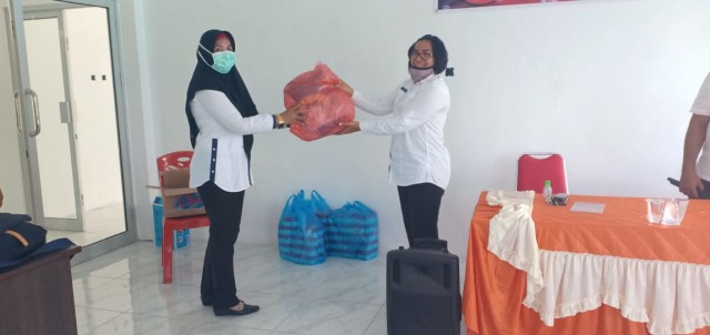 Kadinkes Halbar, Rosfinjte Kalengit saat memberika bantuan berupa APD secara simbolis kepada Kepala Puskesmas Sidangoli, Mitrawati di posko Covid-19 Halbat. Foto: Istimewa