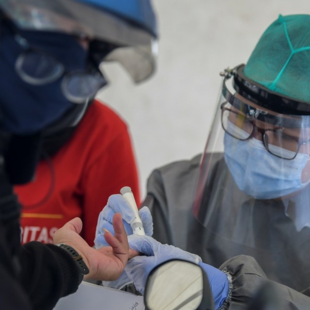 Petugas medis mengambil sampel darah jurnalis saat Rapid Test COVID-19 secara Drive-Thru di Halaman Gedung Kementerian Kominfo, Jakarta, Rabu (8/4). Foto: ANTARA FOTO/Galih Pradipta