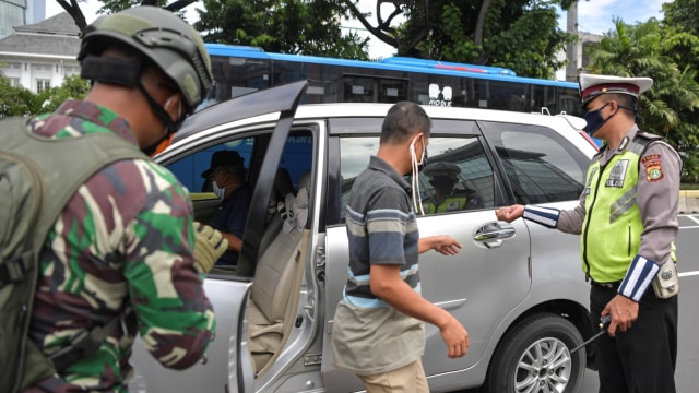 Petugas melakukan imbauan kepada pengendara motor untuk dapat mematuhi penerapan PSBB di kawasan Salemba, Jakarta (11/4). Foto: ANTARA FOTO/Nova Wahyudi
