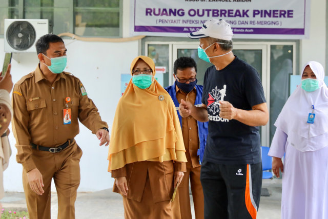 Direktur RSUDZA Banda Aceh, Azharuddin (kiri) saat mengobrol dengan pasein AJ (baju hitam) yang dinyatakan telah sembuh dari COVID-19 dan diperbolehkan pulang ke rumah, Senin (13/4). Foto: Suparta/acehkini 