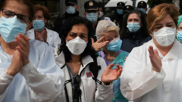 Petugas kesehatan menghadiri penghormatan untuk rekan kerja mereka Esteban yang meninggal karena virus corona di RS Severo Ochoa di Spanyol, Senin (13/4). Foto: REUTERS / Susana Vera