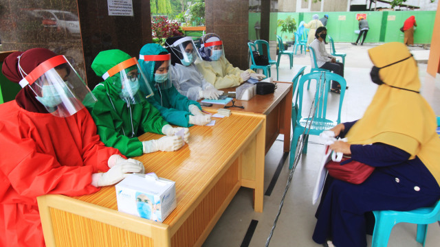 Tenaga medis menggunakan alat pelindung diiri saat melayani warga yang akan berobat di Pusat Kesehatan Masyarakat (Puskesmas) Dumai Kota di Dumai, Riau. Foto:  ANTARA FOTO/Aswaddy Hamid