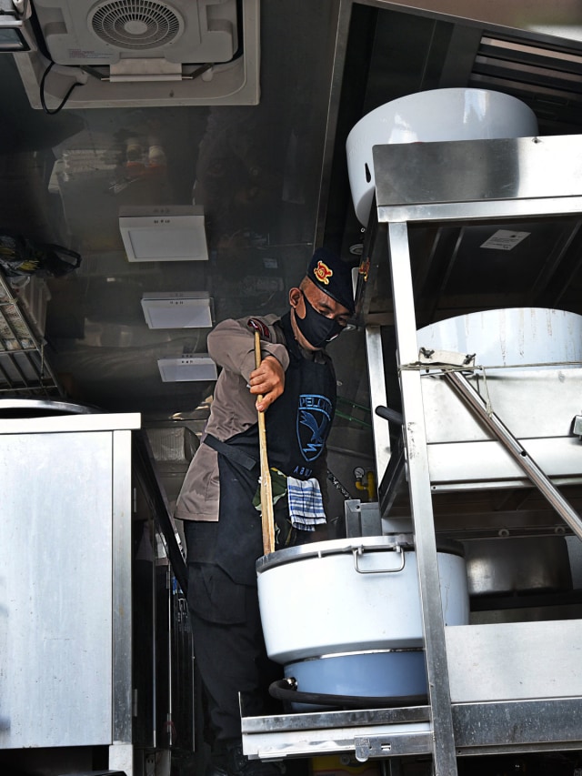 Anggota polisi mamasak nasi saat membuka dapur umum di Alun-alun Serang, Banten, Selasa (14/4/2020). Foto: Antara/ASEP FATHULRAHMAN