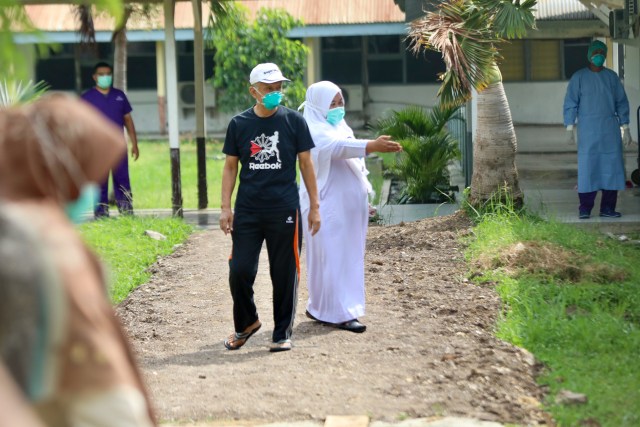 AJ (baju hitam) warga Kota Banda Aceh yang dinyatakan telah sembuh dari COVID-19 dan diantar pulang ke rumahnya dari RSUDZA. Foto: Suparta/acehkini