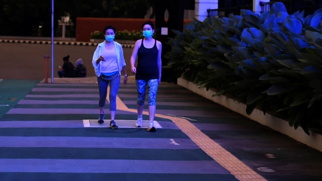Dua warga berolah raga saat pemberlakukan Pembatasan Sosial Berskala Besar (PSBB) untuk memutus rantai penyebaran COVID-19 di kawasan Senayan, Selasa (14/4). Foto: ANTARA FOTO/Wahyu Putro A