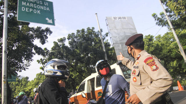 Petugas kepolisian memeriksa pengendara motor yang berpenumpang saat penerapan PSBB di perbatasan Jakarta - Depok, Depok, Jawa Barat, Rabu (15/4/2020). Foto: Antara/Asprilla Dwi Adha