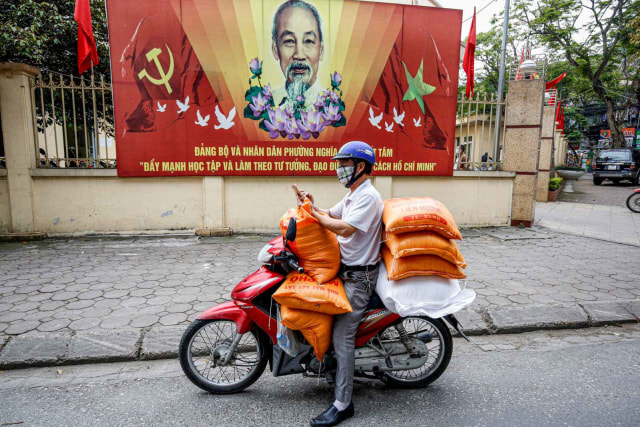 Warga mengantarkan beras yang akan dibagikan gratis di Hanoi, Vietnam. Foto: Reuters/Kham