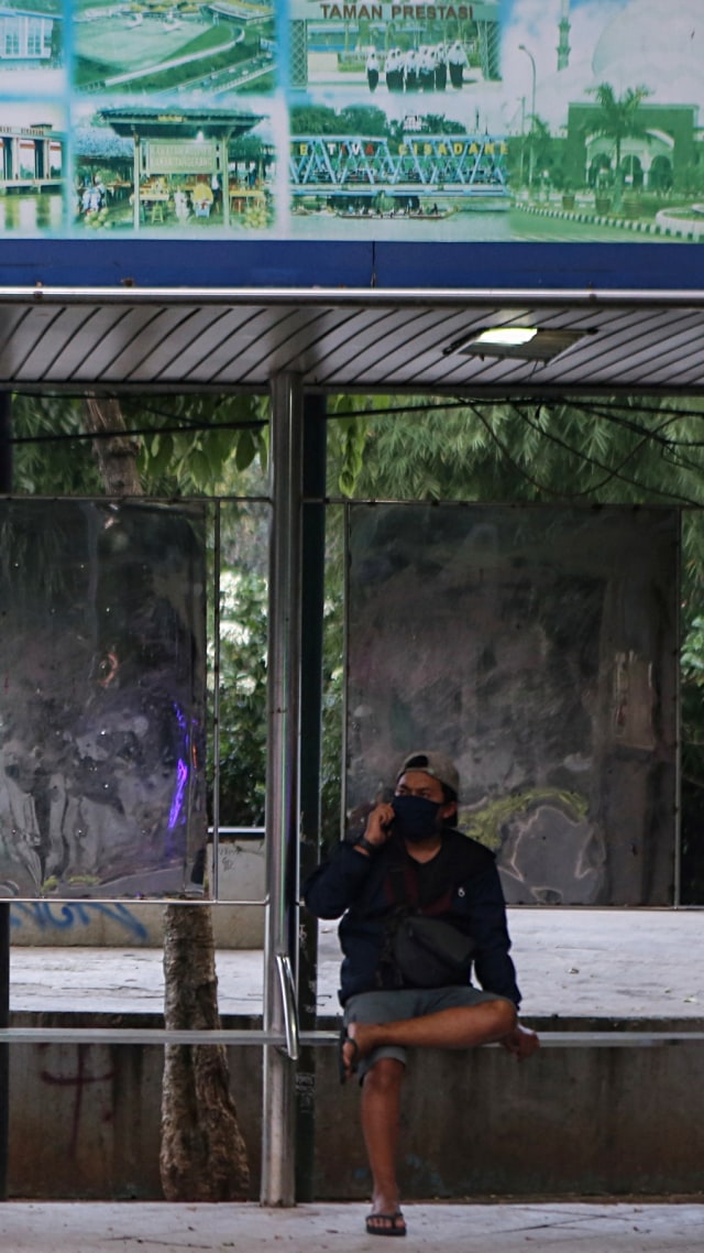 Seorang warga menunggu angkutan umum di halte di Cikokol, Kota Tangerang, Banten, Minggu (19/4). Foto: ANTARA FOTO/Fauzan