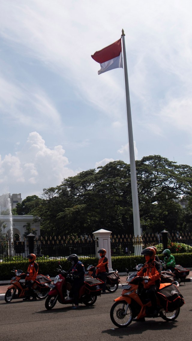 Pegawai PT POS Indonesia (Persero) berkoordinasi sebelum pelepasan distribusi bantuan sosial sembako di depan Istana Merdeka, Jakarta, Senin (20/4). Foto: ANTARA FOTO/Sigid Kurniawan