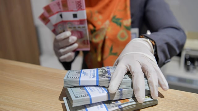Karyawan menghitung uang rupiah dan dolar AS di Bank Mandiri Syariah, Jakarta, Senin (20/4/2020). Foto: ANTARA FOTO/Nova Wahyudi