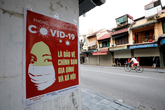 Sejumlah poster soal virus corona terpasang di Kota Hanoi, Vietnam, Senin (20/4). Foto: Reuters/Kham