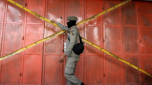 Petugas Satpol PP Kota menyegel sebuah toko. Foto: ANTARA FOTO/Rony Muharrman