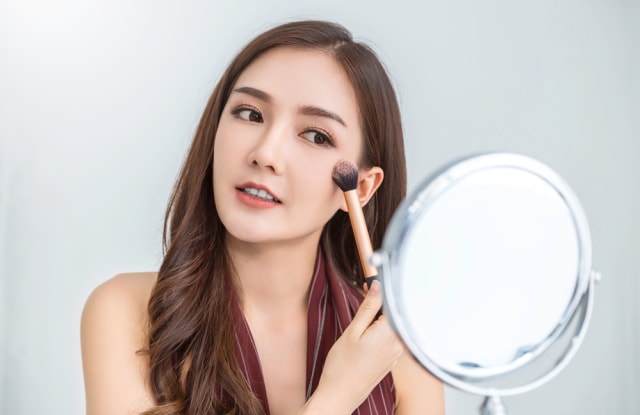 Ilustrasi perempuan merias wajah. Foto: dok. Shutter Stock