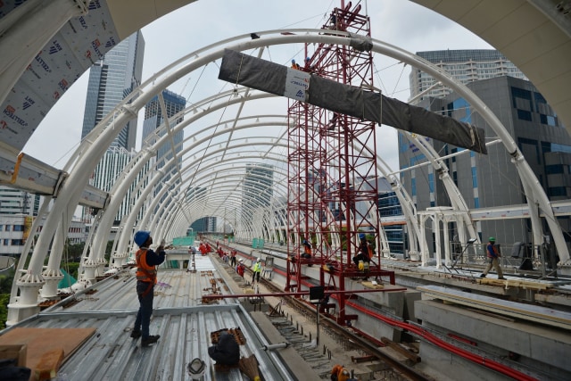 Pekerja menyelesaikan pembangunan Stasiun Kereta Api Ringan atau Lintas Rel Terpadu (LRT) Rasuna Said di Kuningan, Jakarta, Selasa (21/4). Foto: ANTARA FOTO/Aditya Pradana Putra