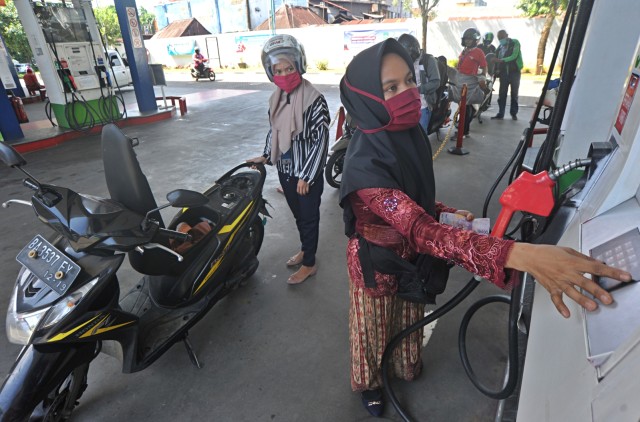 Seorang petugas menggunakan baju kebaya saat melayani pembeli BBM di SPBU Coco Ulak Karang, Padang, Sumatera Barat, Selasa (21/4). Foto: ANTARA FOTO/Iggoy el Fitra