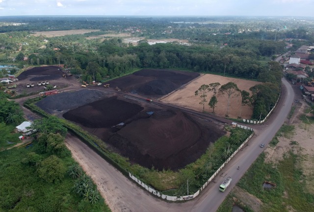 Foto udara tempat penumpukan sementara batu bara di Muarojambi, Jambi, Selasa (21/4). Foto: ANTARA FOTO/Wahdi Septiawan
