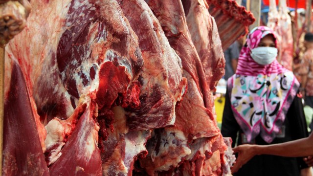 Calon pembeli memilih daging sapi pada hari meugang pertama atau meugang kecil di pasar daging tradisional Lhokseumawe, Aceh. Foto:  ANTARA FOTO/Rahmad