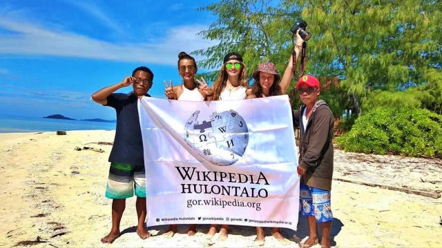 Marwan Mohamad bersama turis asing membentangkan bendera Wikipedia Hulontalo. Rabu, (22/4). Foto: Dok istimewa