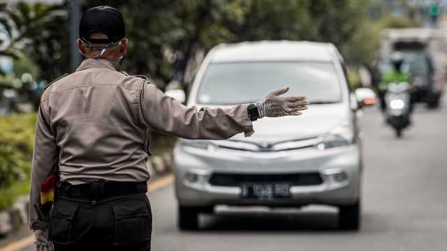 Polisi mengarahkan kendaraan roda empat untuk menjalani pemeriksaan saat penerapan Pembatasan Sosial Berskala Besar (PSBB) di Pasteur, Bandung, Jawa Barat. Foto: Antara/Agung Rajasa