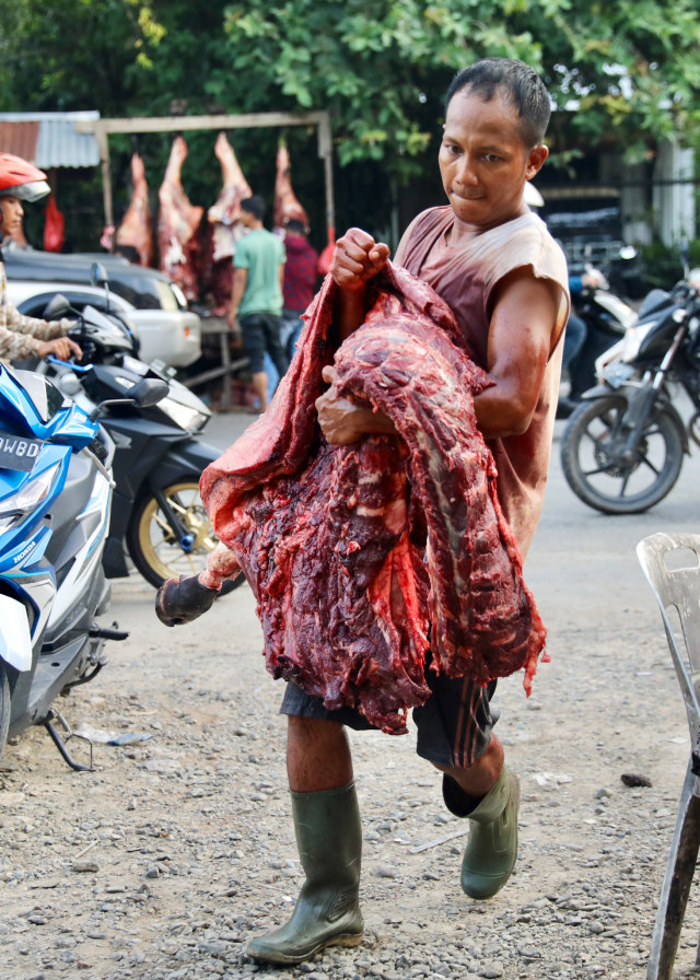 Penjual mengangkat daging. Foto: Suparta/acehkini