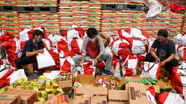 Pekerja mengemas paket bantuan sosial (bansos) di Gudang Food Station Cipinang, Jakarta, Rabu (22/4/2020). Foto: ANTARA FOTO/M Risyal Hidayat