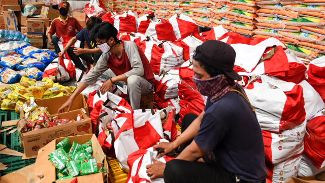 Pekerja mengemas paket bantuan sosial (bansos) di Gudang Food Station Cipinang, Jakarta, Rabu (22/4/2020). Foto: ANTARA FOTO/M Risyal Hidayat