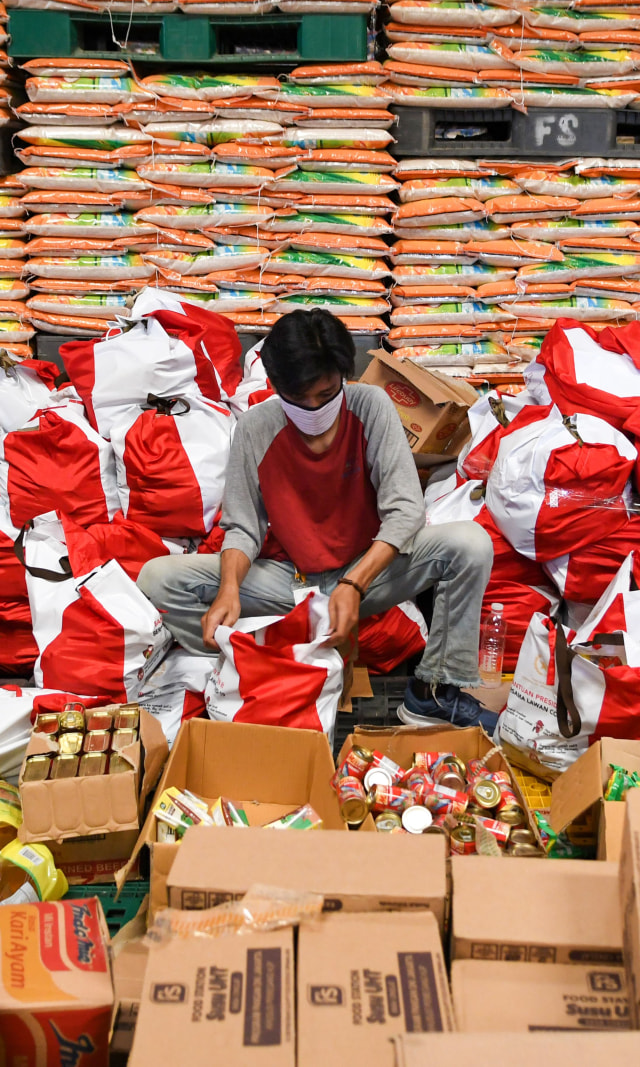 Pekerja mengemas paket bantuan sosial (bansos) di Gudang Food Station Cipinang, Jakarta, Rabu (22/4/2020). Foto: ANTARA FOTO/M Risyal Hidayat