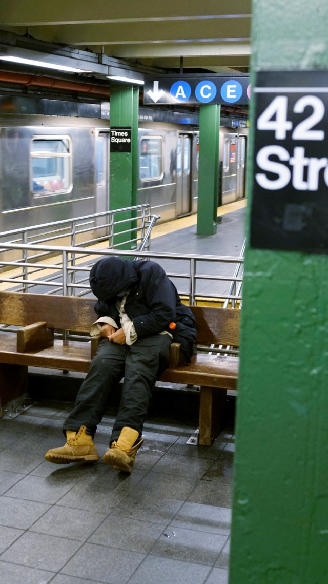 Seorang tunawisma tidur di kursi stasiun kereta bawah tanah New York ketika wabah virus corona berlanjut di New York, AS. Foto: REUTERS/Lucas Jackson