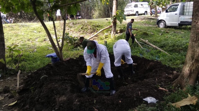 Petugas dari RSUD dr Sosodoro Djatikoesomo Bojonegoro bersama warga setempat saat melakukan pemakaman jenazah warga Desa Campurejo Kecamatan Bojonegoro Kota yang meninggal di RSUD Bojonegoro. Kamis (23/04/2020)