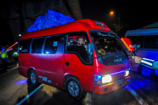 Polisi menghalau mini bus yang membawa pemudik di tol Jakarta-Cikampek untuk keluar ke Gerbang tol Cikarang Barat, Kabupaten Bekasi, Jawa Barat, Jumat (24/4). Foto: ANTARA FOTO/Fakhri Hermansyah