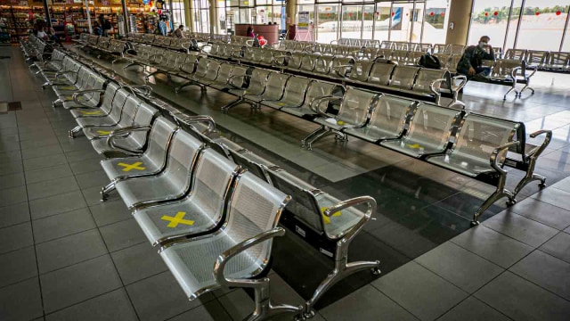 Penumpang duduk di ruang tunggu keberangkatan yang lengang di terminal keberangkatan Bandara Hang Nadim, Batam, Kepulauan Riau, Jumat (24/4/2020). Foto: Antara/Hendra Nurdiyansyah