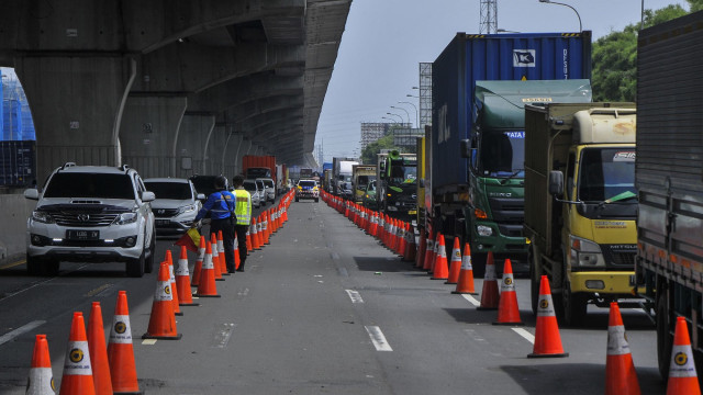 Sejumlah polisi berjaga saat dilakukan penyekatan kendaraan di tol Jakarta-Cikampek, Cikarang, Kabupaten Bekasi, Jawa Barat. Foto: ANTARA FOTO/ Fakhri Hermansyah