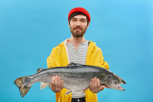 Ilustrasi pria membawa ikan salmon Foto: Shutterstock