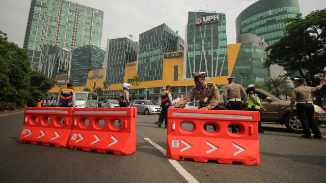 Polisi memasang 'water barrier' di Bundaran Waru, Surabaya, Jawa Timur, Selasa (28/4). Foto: ANTARA FOTO/Didik Suhartono