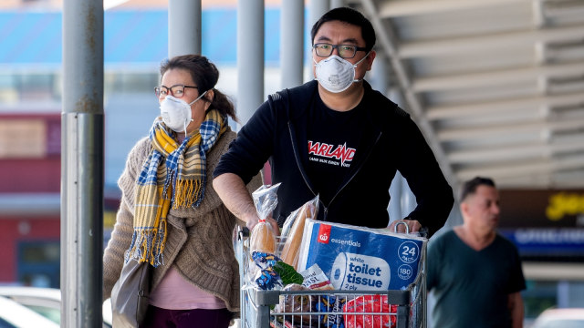 Warga memakai masker saat meninggalkan salah satu supermarket di Wellington, Selandia Baru. Foto: Marty MELVILLE / AFP