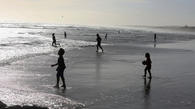 Pengunjung beraktivitas di pantai, usai Selandia Baru melonggarkan peraturan ketat untuk mencegah virus corona, di Auckland, Selandia Baru, Selasa (28/4). Foto: REUTERS/Ruth McDowall 