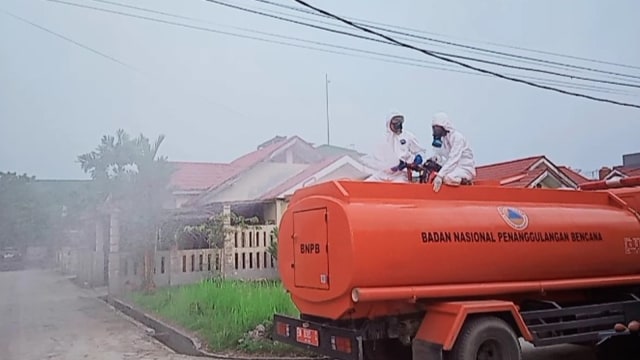 PETUGAS saat menyemprotkan cairan disinfektan ke rumah pasangan suami istri RBT dan JG, pasien positif COVID-19 di Pangkalan Kerinci. Kini pasangan tersebut serta seorang anaknya dinyatakan sembuh. 