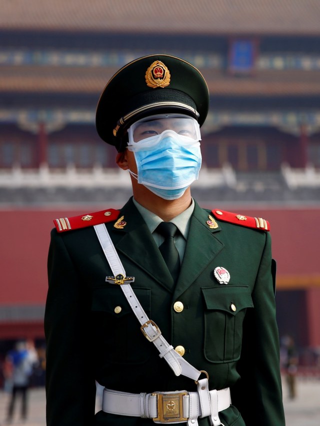 Petugas memakai masker berjaga di luar Kota Terlarang, Beijing, China. Foto: REUTERS / Tingshu Wang