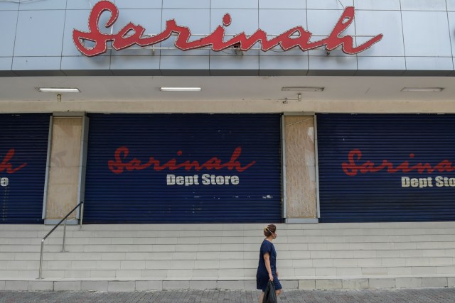 Warga melintasi toko yang tutup di pertokoan Sarinah akibat merebaknya wabah virus corona di Jakarta. Foto: ANTARA FOTO/Galih Pradipta
