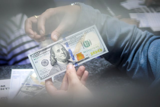 Warga menukarkan mata uang dollar AS di sebuah gerai penukaran mata uang di Jakarta. Foto: ANTARA FOTO/Galih Pradipta