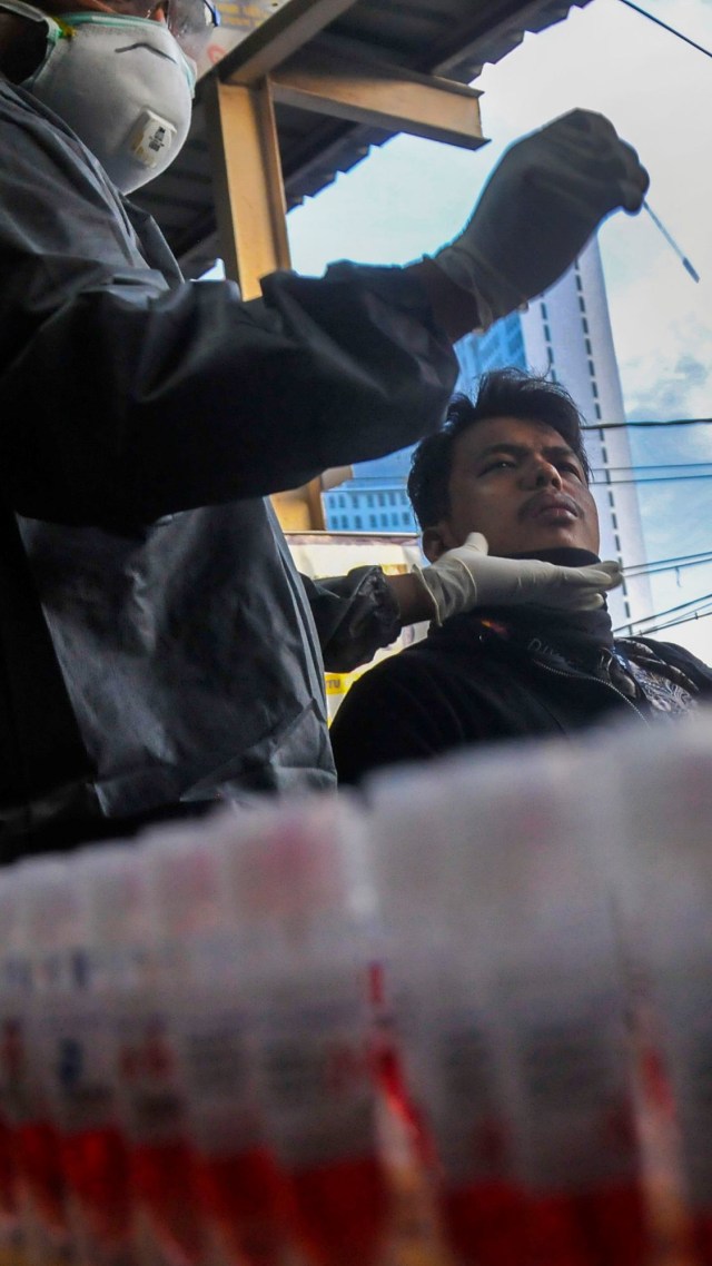 Petugas medis mengambil sampel penumpang KRL Commuter Line saat tes swab di Stasiun Bekasi, Jawa Barat. Foto: ANTARA FOTO/ Fakhri Hermansyah