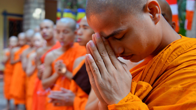 Seorang biksu berdoa untuk memperingati hari Waisak di Maha Bodhi Society, Bangalore, India. Foto: AFP/Nhac NGUYEN