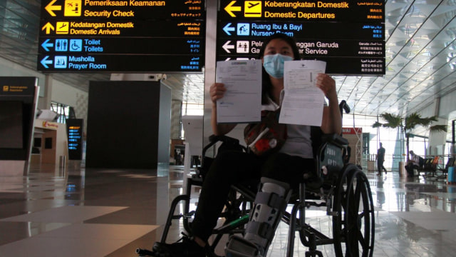 Seorang calon penumpang dengan ijin khusus berobat menunjukan surat syarat terbang di Terminal 3 Bandara Soekarno Hatta, Tangerang, Banten. Foto: ANTARA FOTO/Muhammad Iqbal